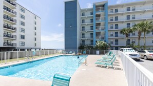 A swimming pool with lounge chairs and a white fence. - IS655- *Labor Day Special!*  Beach Front, Park & Walk! Look at This View! (Gulf Shores)