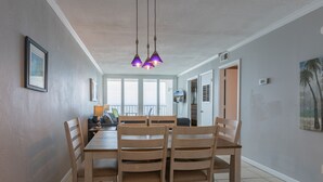 A dining area with a wooden table and chairs, pendant lights, and a view of the outdoors. - IS655- *Labor Day Special!*  Beach Front, Park & Walk! Look at This View! (Gulf Shores)