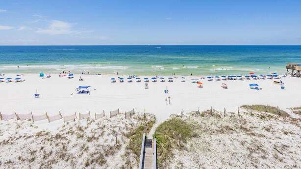 A beach with a wooden boardwalk leading to the shore, sandy beach, and umbrellas. - IS655- *Labor Day Special!*  Beach Front, Park & Walk! Look at This View! (Gulf Shores)