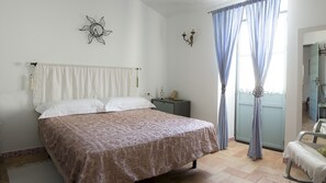 Cozy retreat with a large bed, bedside table, and decorative wall piece.
