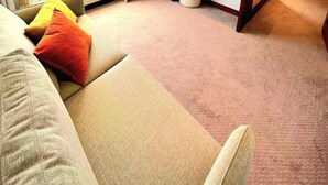 Une chambre d’hôtel moderne dotée d’une grande fenêtre, d’un lit, d’un bureau et d’une télévision.