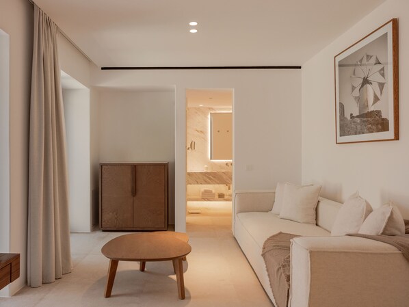 A modern living room with a sofa, a wooden cabinet, a small table, and a framed picture on the wall. - Cali Mykonos (Mykonos)