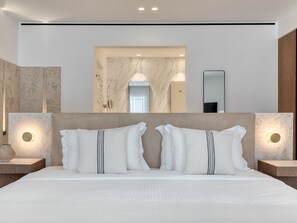 Una habitación de hotel moderna con una cama grande, dos mesitas de noche, una pared de mármol y un espejo.
