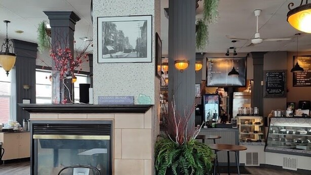 A restaurant interior with a bar area, seating, and a display case. - The Roses Heritage Inn (St. John's)