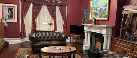 A traditional living room with a fireplace, leather sofas, and classic decor.