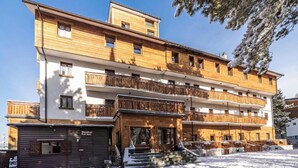 A multi-story hotel with wooden balconies and a ski lodge area. - Hotel Gran Baita (Sauze d'Oulx)