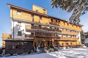 A multi-story hotel with wooden balconies and a ski lodge area. - Hotel Gran Baita (Sauze d'Oulx)