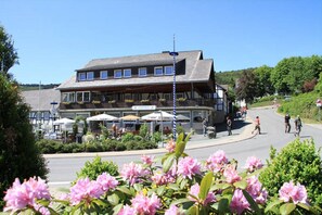 A traditional building with a balcony, outdoor seating, and a clear sky. - Hotel Gasthof Müller (Winterberg)