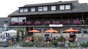 En byggnad med en balkong, utomhusmöbler och blomlådor.