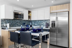 A modern kitchen with a stainless steel refrigerator, a microwave, and a built-in oven.