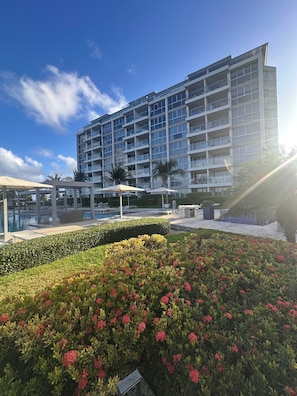 Un hôtel moderne, doté de plusieurs étages, d’une piscine extérieure et de jardins bien entretenus.