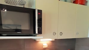 A compact kitchen with a microwave, coffee machine, dishwasher, and a sink. - 100m from resort center, 4th floor, view mountain, balcony, parking, tv, ski locker, 40m² (Les Deux Alpes)