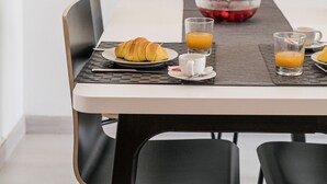 A dining table with a laptop, croissant, and glasses of orange juice. - LAGOS CLASSIC by HOMING (Lagos)