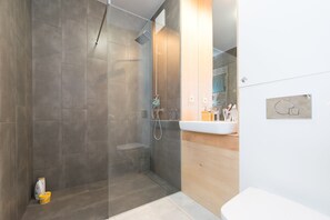 City appartement | Badkamer | Een douche, handdoeken
