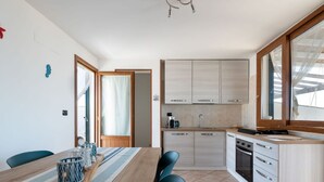 A modern kitchen with wooden cabinets, a built-in oven, and a large window.