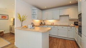 Una cocina moderna con armarios blancos, una isla central y horno empotrado.