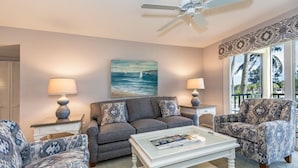 A living room with a grey sofa, patterned armchairs, a white coffee table, and two lamps. - Condo#203 Updated beautiful  condo on Siesta Key with an upscale comfortable coastal look and feel. (Sarasota)