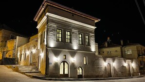 Un edificio histórico con fachada de piedra, varias ventanas y una entrada central con puerta.