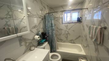 Bathtub, hair dryer, towels, toilet paper