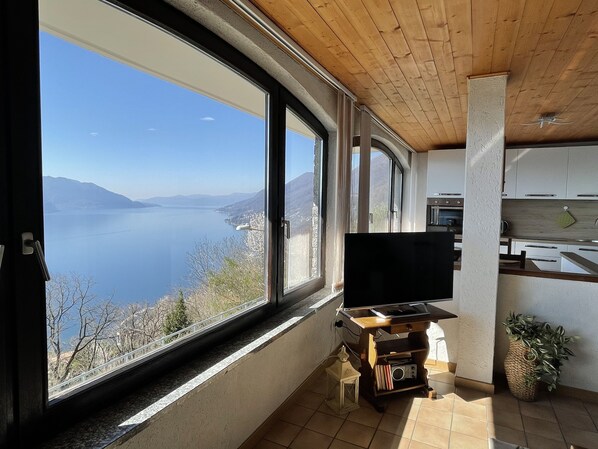 Una cocina moderna con un amplio ventanal con vistas a un lago y montañas.