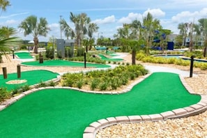 Play a round of golf amidst lush gardens and palm trees.