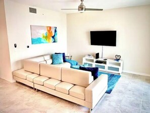 Relax in this stylish living room with a comfortable sofa, flat-screen TV, and decorative touches.