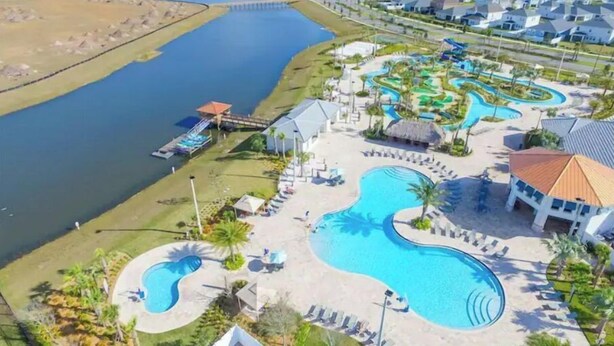 Ein Resort mit mehreren Schwimmbecken, einem Wasserpark und einer Anlegestelle, die in einen See hineinreicht.