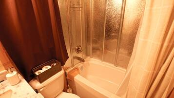 Une salle de bain avec des toilettes, un lavabo et une baignoire.