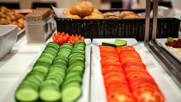 Un bufé con pepinos y tomates en rodajas.