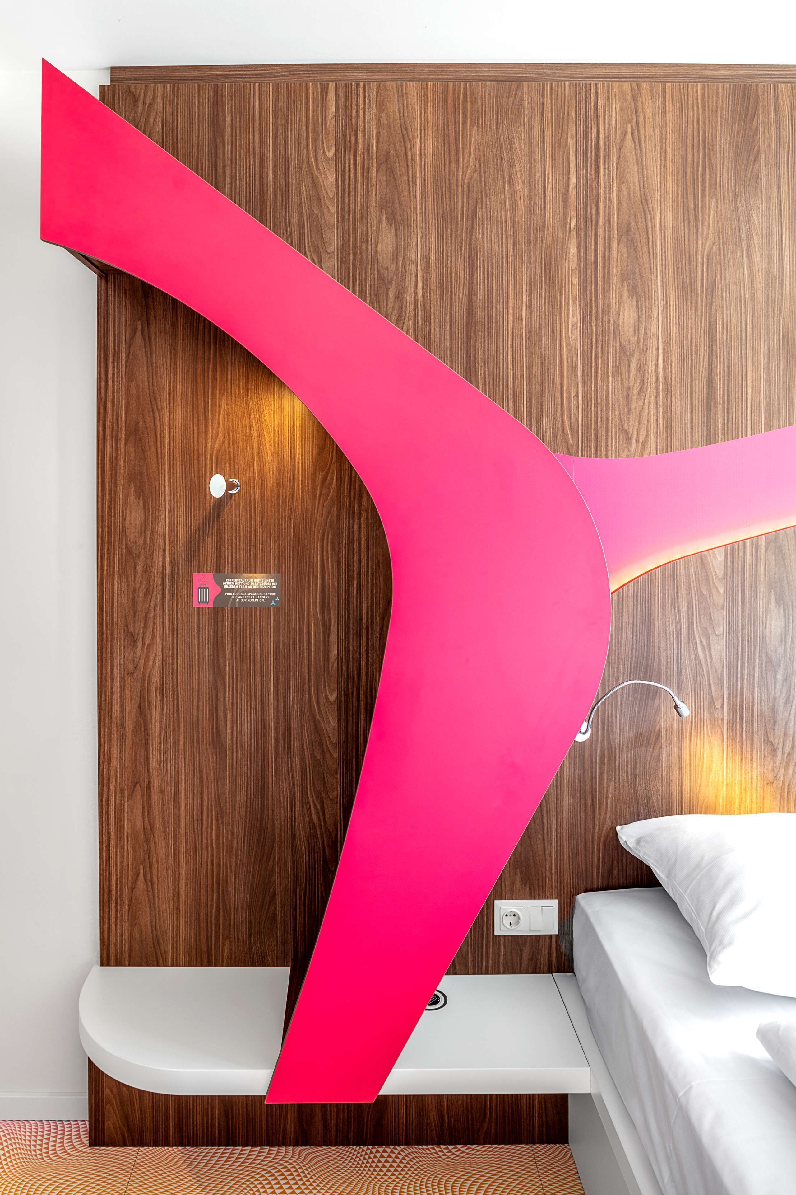 Ein modernes Zimmer mit einer Holzwand, einem weißen Bett und einer Bank.