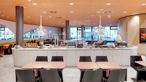 A modern restaurant with a central bar, multiple seating areas, and pendant lighting. - Prize by Radisson, Vienna City (Vienna)