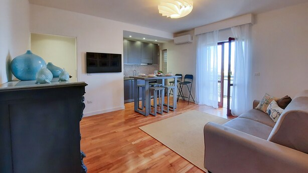 A modern living room with a sofa and a dining area with chairs.