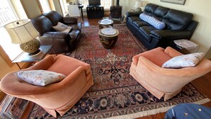 Un salon avec deux canapés en cuir, une table basse et un tapis à motifs.