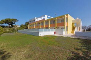 Un edificio moderno de varios pisos con techo plano, ventanas grandes y fachada plana.
