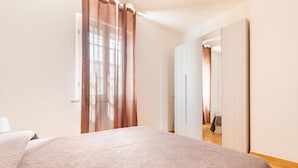 Ein Schlafzimmer mit einem großen Bett, einem Kleiderschrank und einem Spiegel.