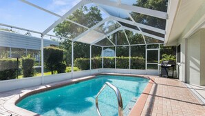 Una piscina coberta amb una escala metàl·lica, envoltada per un pati de maó i una tanca blanca.