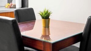 Une table de conférence, avec une plante en pot placée au centre, entourée de chaises.