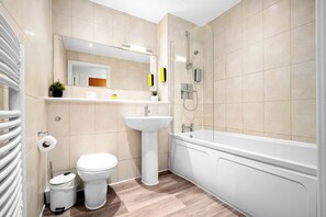Ein modernes Badezimmer mit Toilette, Waschbecken und Badewanne.