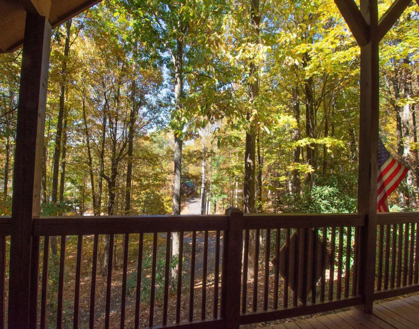 A wooden deck with a view of a forested area.