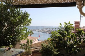 A balcony with a view of a marina and the sea.