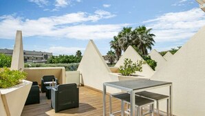 A rooftop terrace with a table and chairs, surrounded by palm trees and a clear sky. - Naturist Village - Le Diamond X Héliopolis Luxe, Naturist Village (Agde)