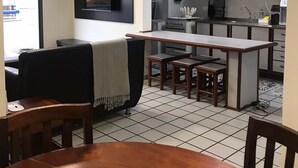 Un espacio habitable compacto con kitchenette, comedor y zona de estar con televisor.