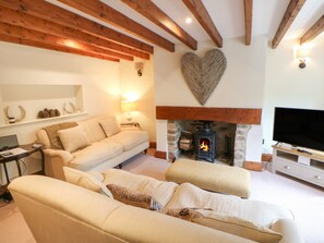 Una sala de estar acogedora con chimenea, un sofá y un televisor.