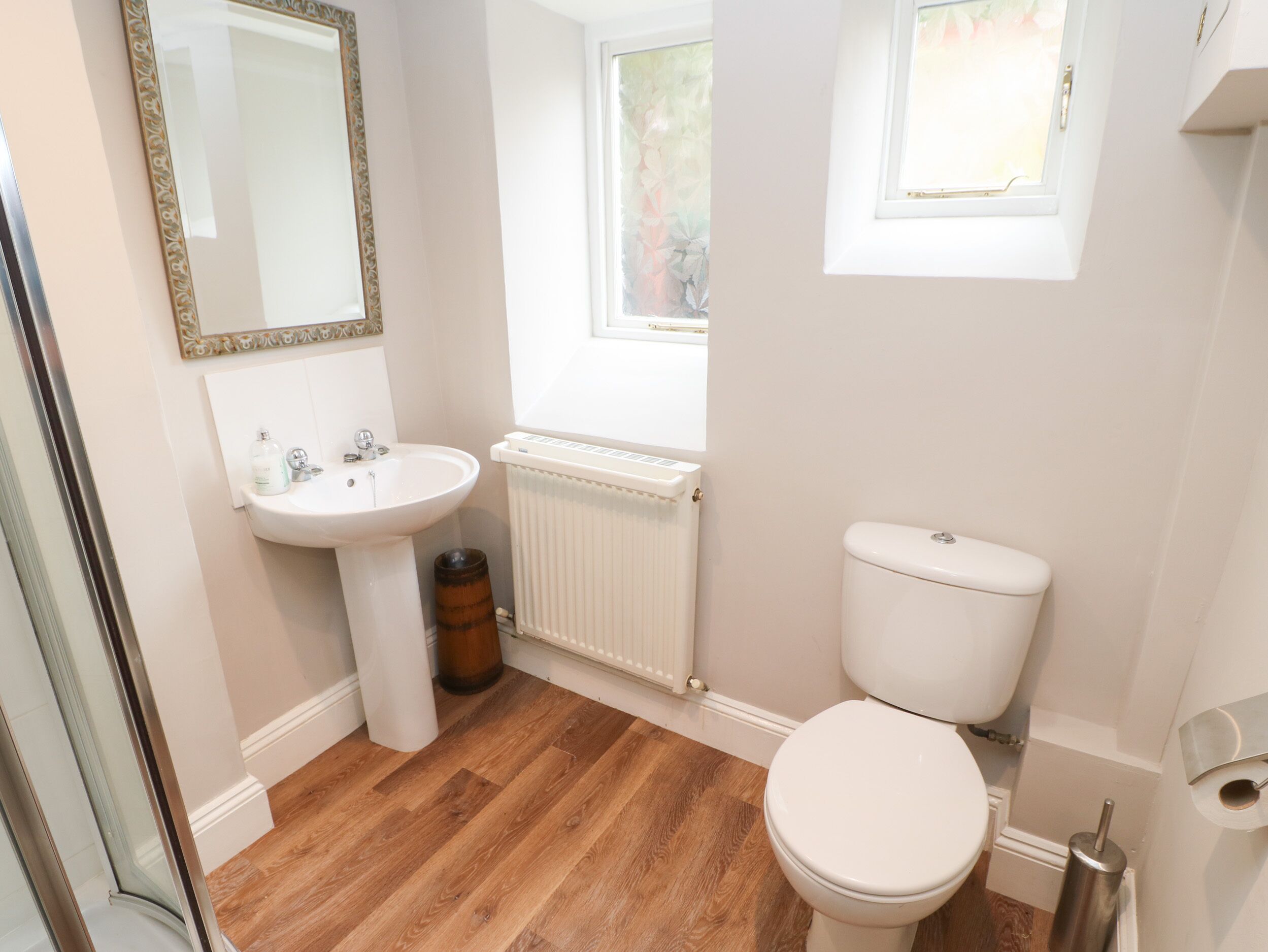 A bathroom with a white sink, toilet, and radiator.