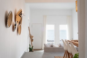 Enjoy a casual dining experience in this room, featuring a dining area with a table and chairs, and take in the stunning sea views from the large window.