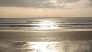 A beach with a calm sea and a cloudy sky. - Family home- Charm of the countryside and  the wildness of the Ocean. (Plovan)