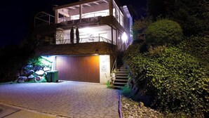 Une maison moderne à deux étages, dotée d’un garage, d’un balcon et d’un escalier menant à l’étage supérieur.