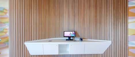 A reception desk with a flat-screen TV, a small digital clock, and a card reader.