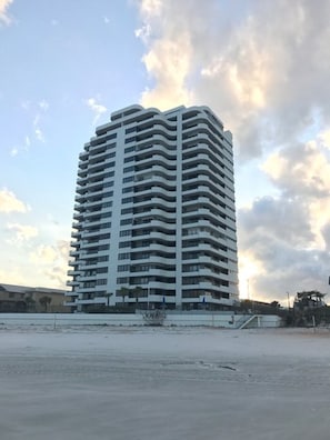 Stunning high-rise building with spacious balconies overlooking a flat open area.