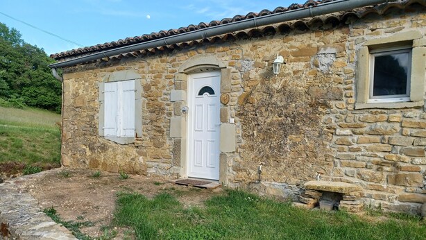 A stone building with a tiled roof, a white door, and a small window. - Type F2 apartment in a quiet country setting (Comps)